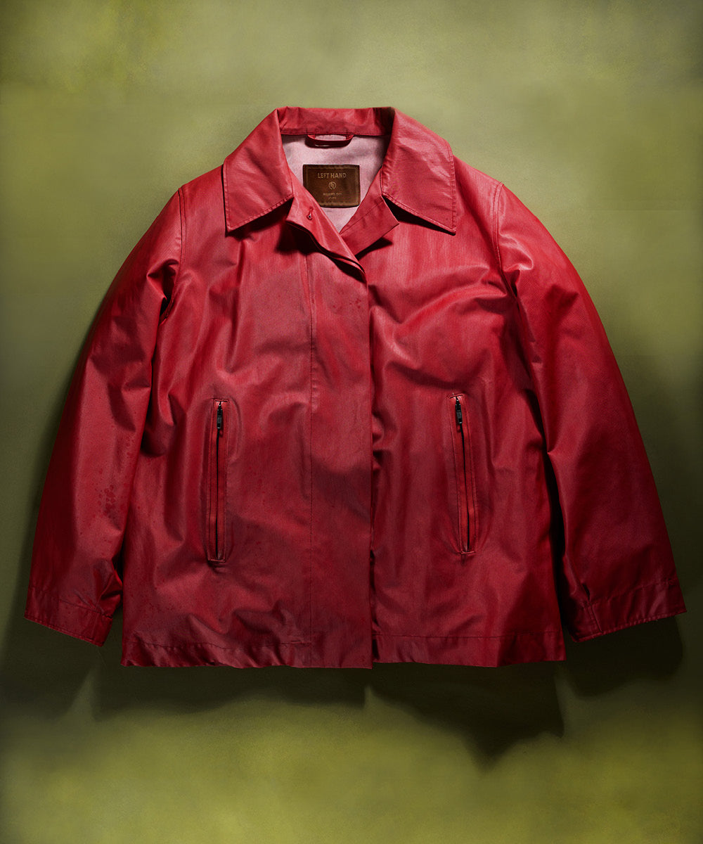 Left Hand Thermojoint Ladies Harrington jacket in deep red with zip pockets and classic collar, displayed on a green backdrop.