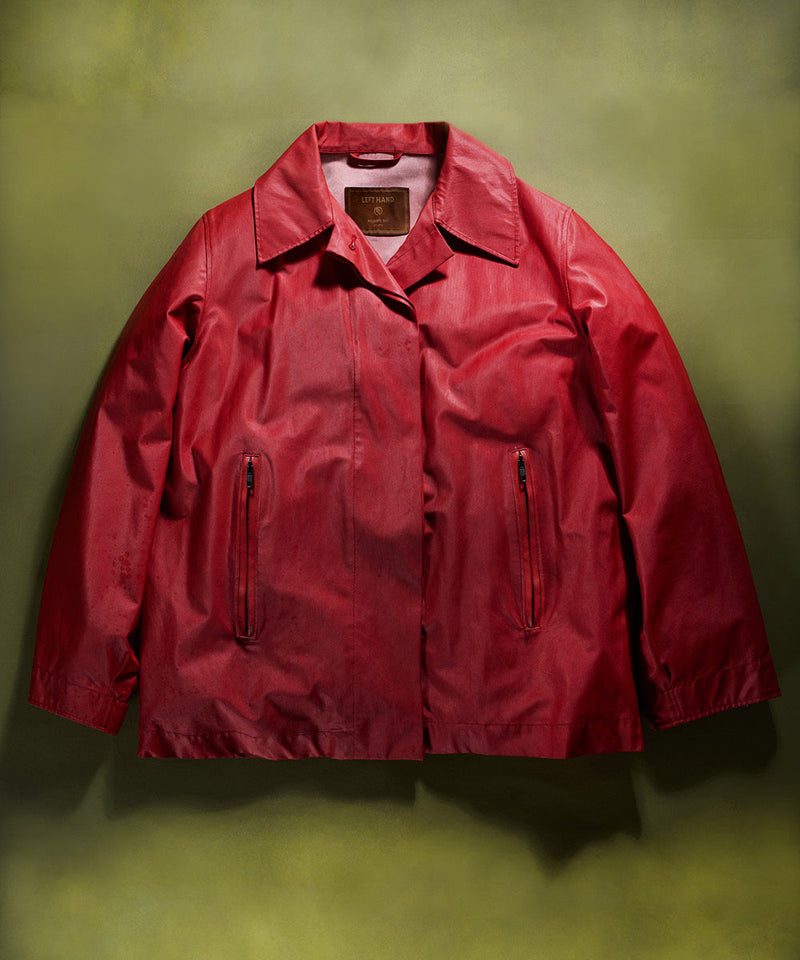 Left Hand Thermojoint Ladies Harrington jacket in deep red with zip pockets and classic collar, displayed on a green backdrop.