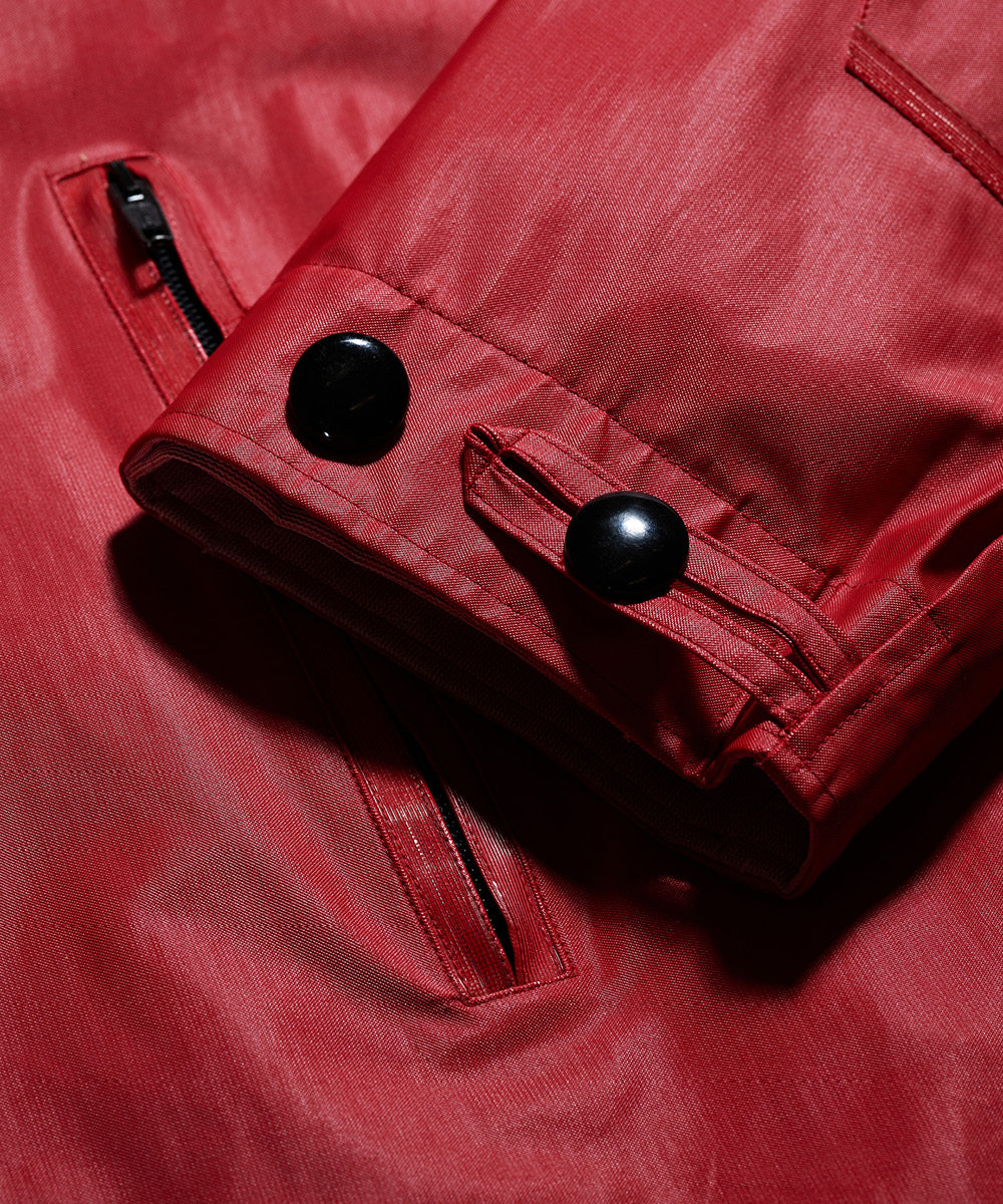 Close-up of a red Left Hand Thermojoint Ladies Harrington jacket with black buttons and zipper